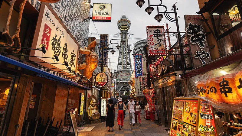 Image description: Restaurants and Tsutenkaku Tower in Osaka, Japan.
