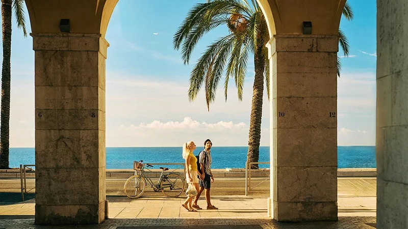 Image description: A couple walking on the Promenade des Anglais in Nice, France.