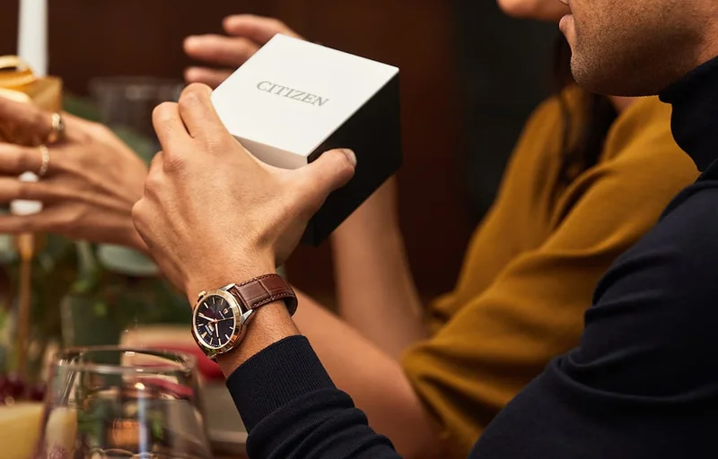 Man wearing a AW0096-06L and holding a gift box