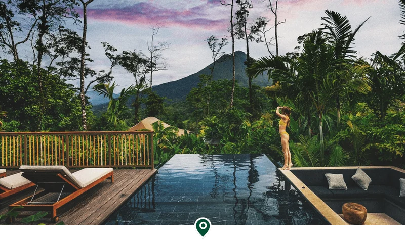 Image Description: A lady standing beside an infinity pool in Nayara Tented Camp, a luxurious jungle resort in Costa Rica
