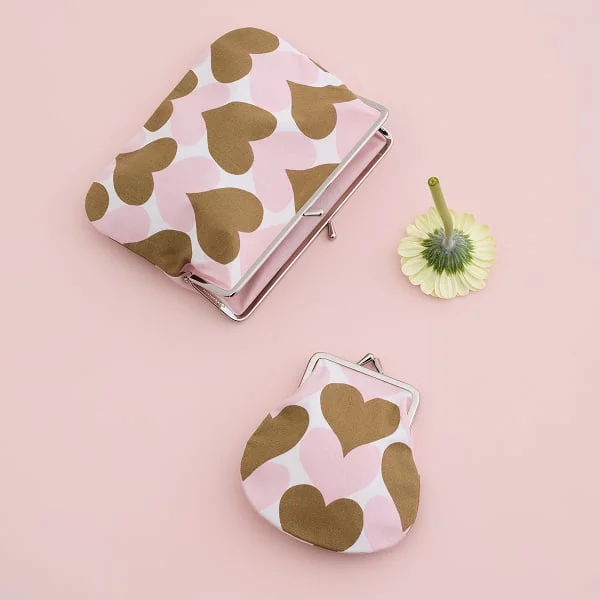 Pienet Sydämet Puolikas kukkaro Purse featuring pink and brown hearts.