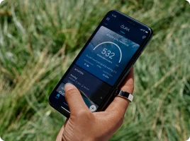 Hand holding phone using Oura app