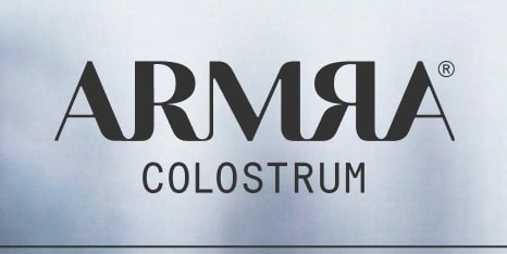 ARMRA Colostrum logo centered on a light, cloudy background.