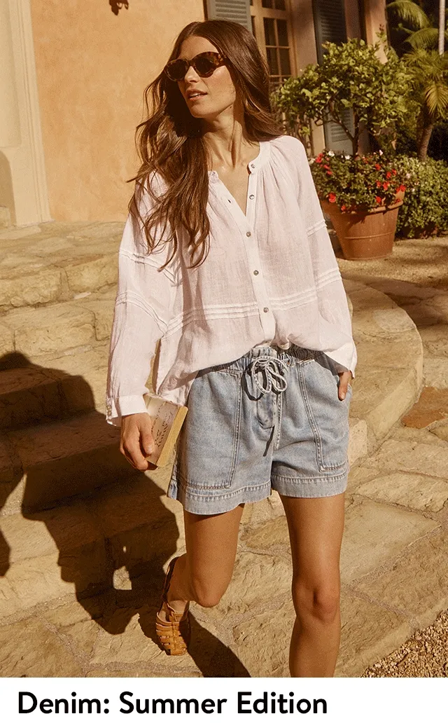 A woman wearing denim shorts and a white blouse. A woman wearing a denim maxi skirt and an eyelet top.