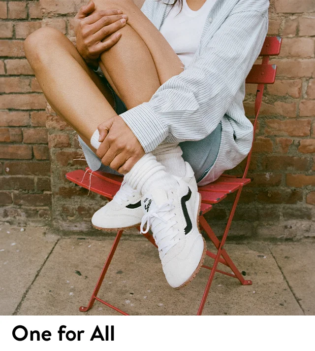 A woman wearing white sneakers.