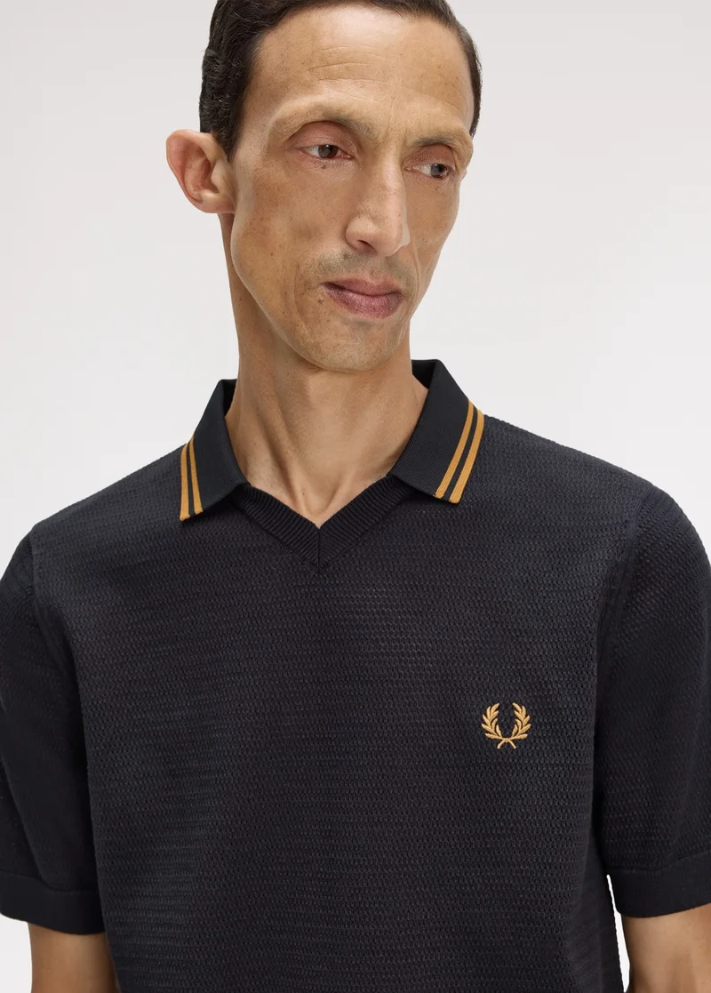 New Releases Men: Model wears a v-neck buttonless collared shirt in black with caramel twin-tipping