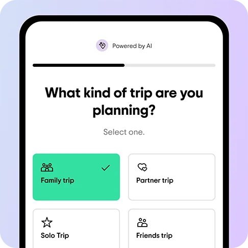 Image Description: A phone screen with the prompt “What kind of trip are you planning?” and the options “Family trip” with an icon of a family, “Partner trip” with an icon of a heart, “Solo trip” with an icon of a star, and “Friends trip” with an icon of two people underneath. “Family trip” is selected in green.