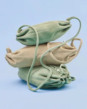 Suede Karla bags stacked on top of one another.
