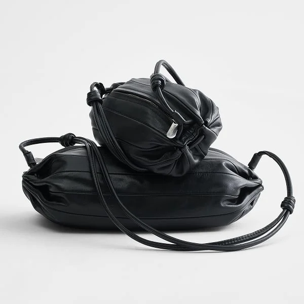 Stacked black leather Karla bags.