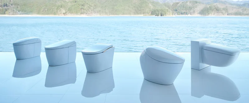 The TOTO NEOREST toilet product line is displayed in front of a scenic blue lake.