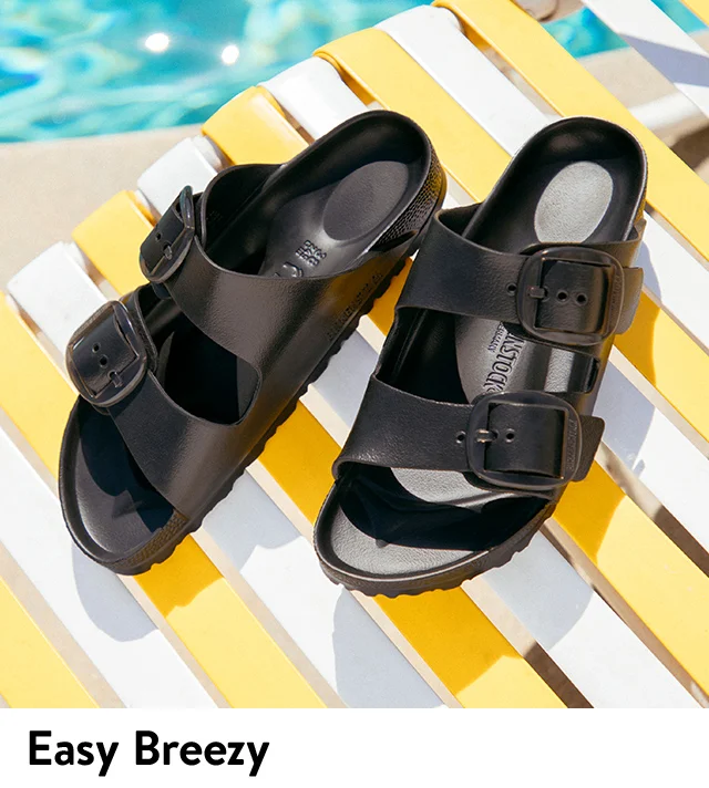 Black Birkenstock slides next to a pool.
