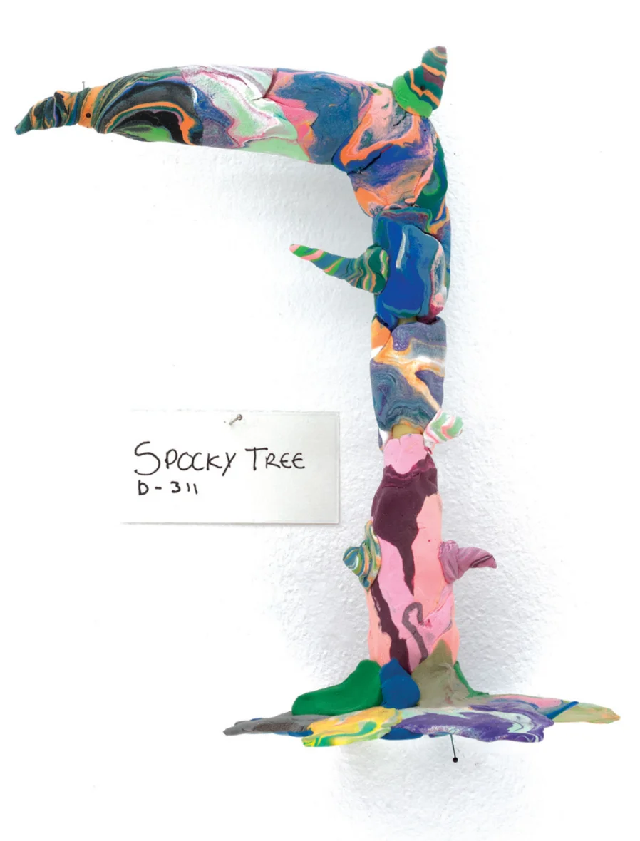 A photograph of a colorful, leafless tree composed of clay, part of Do Ho Suh’s “Artland”