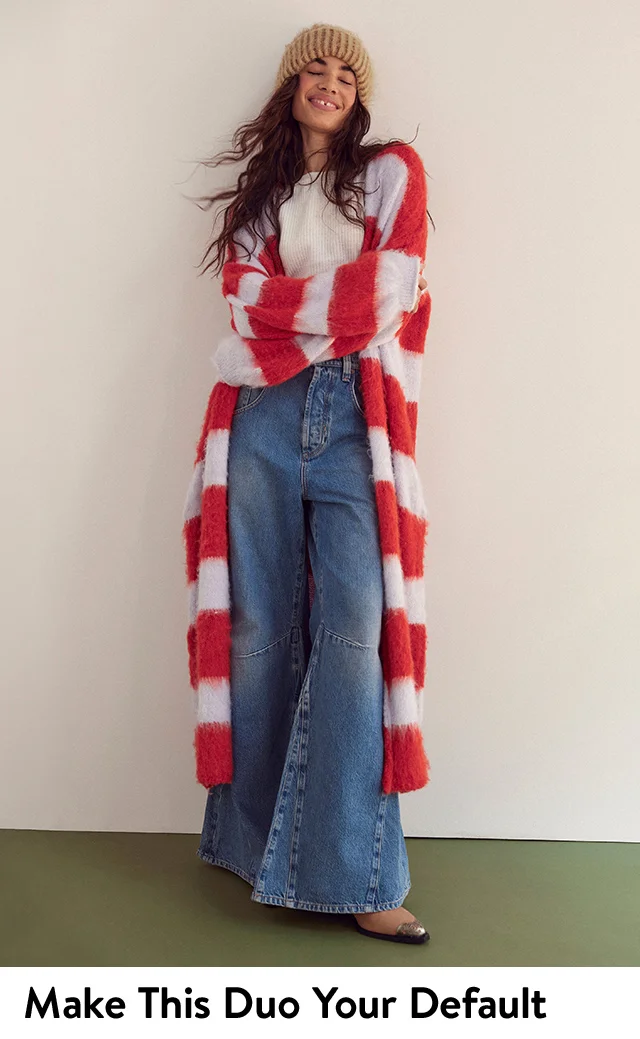 A woman wearing a long striped cardigan with flare jeans.