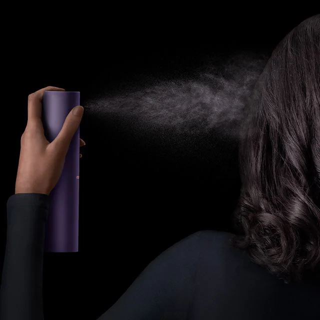 Dyson Chitosan Multi-use styling spray is sprayed onto straight dark hair