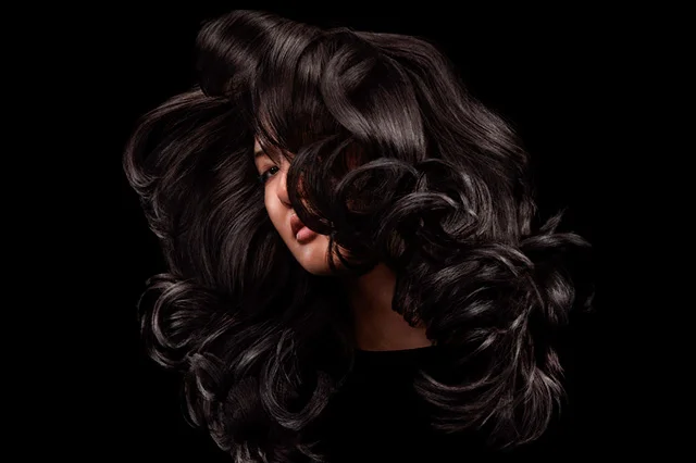 A model with shiny black hair styled with Dyson Chitosan products
