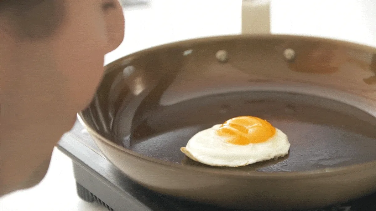 Blowing on an egg in a carbon steel Misen pan