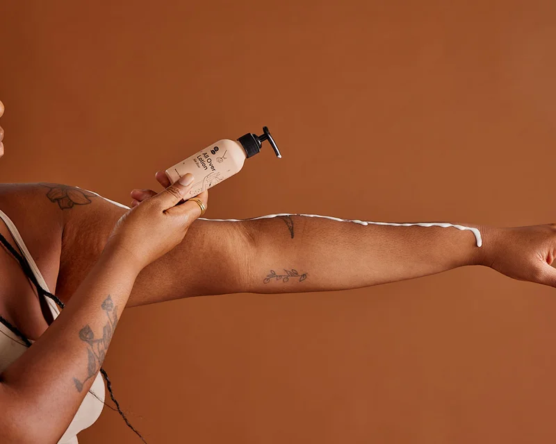 A white line of lotion runs over a brown arm