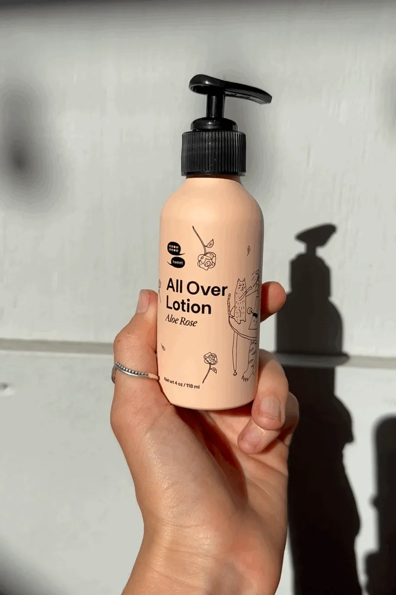 A white hand twirls a bottle against a shadowy wall