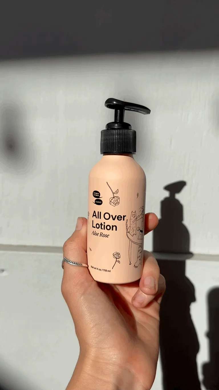 A white hand twirls a pink bottle