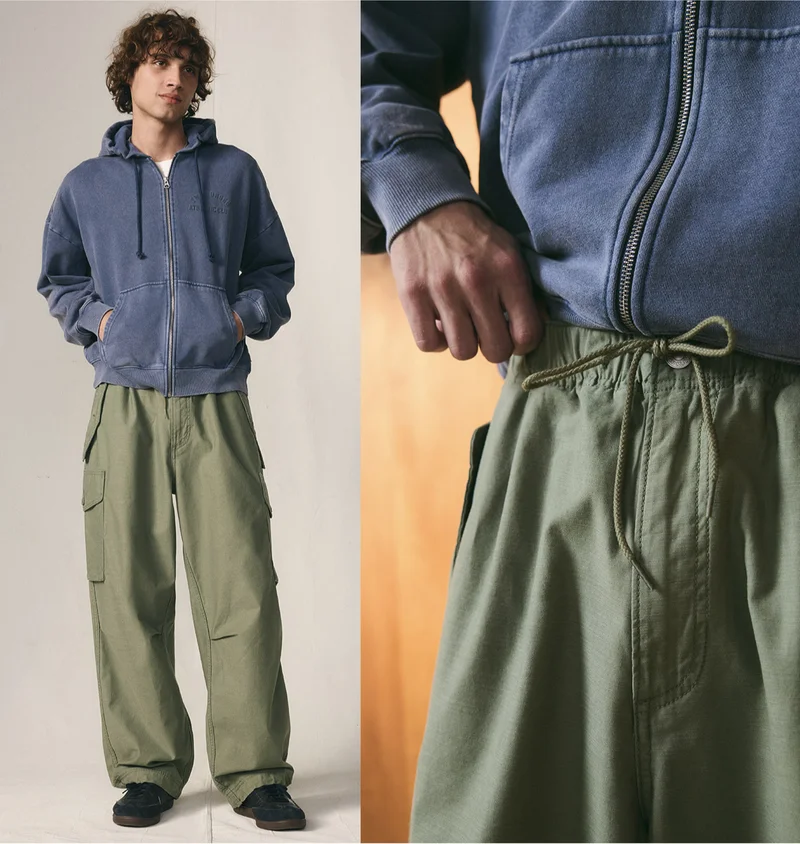 Man wearing green baggy field cargo pants and a blue jacket.