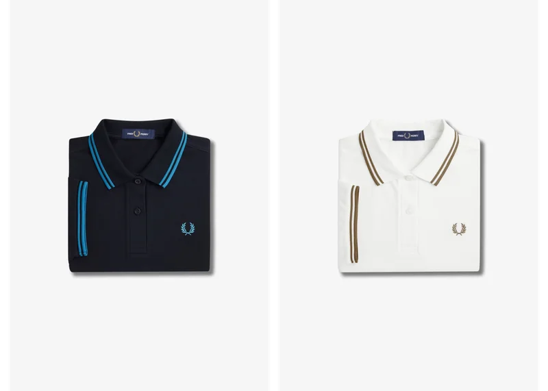 2 folded Fred Perry polo shirts, one black and one black, both with coloured tipping