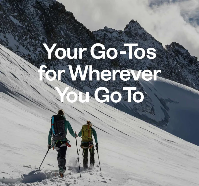 Your go-tos for wherever you go to. Two backcountry skiers skinning toward their objective.