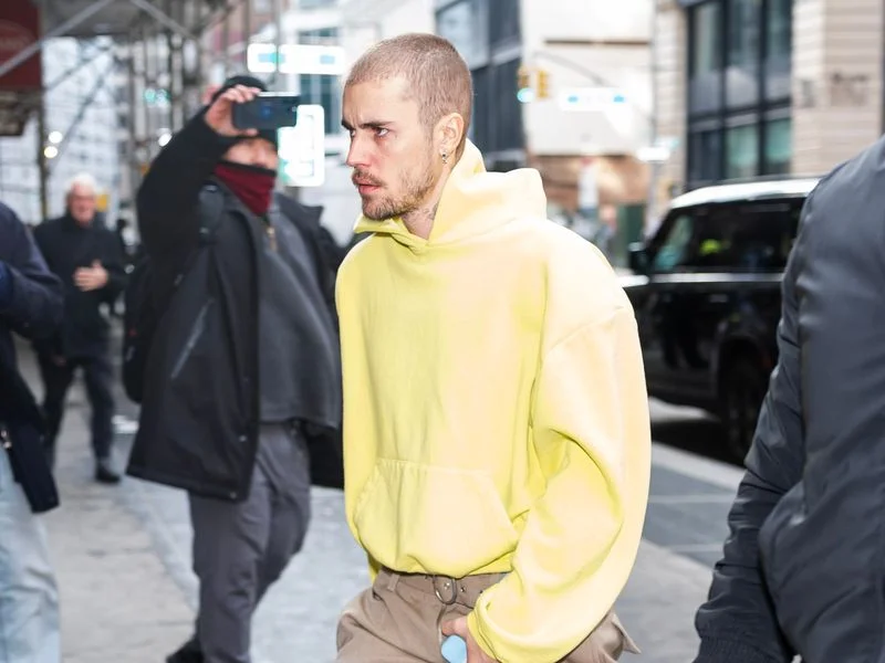 Image may contain: Justin Bieber, Person, Walking, Pedestrian, Adult, Car, Transportation, Vehicle, Clothing, and Footwear