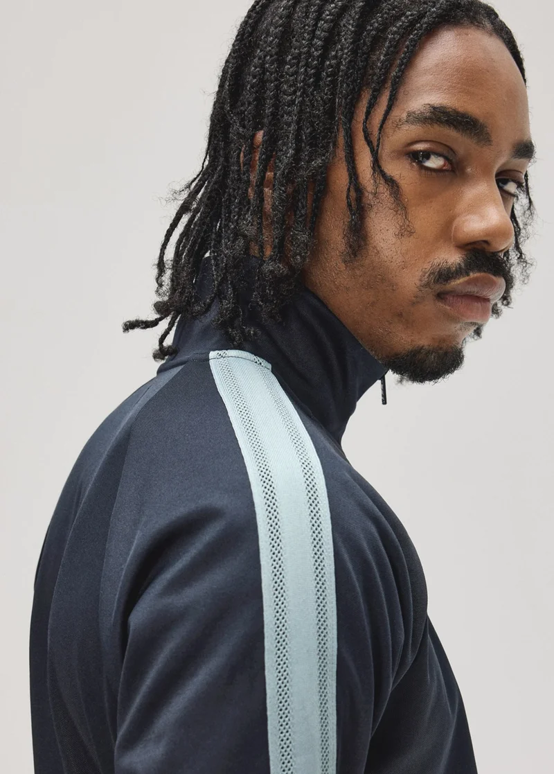 Male model wearing a Fred Perry Mesh Taped Track Jacket in Navy