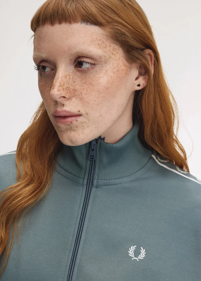 Female model wearing a Taped Track Jacket in Stockport Blue