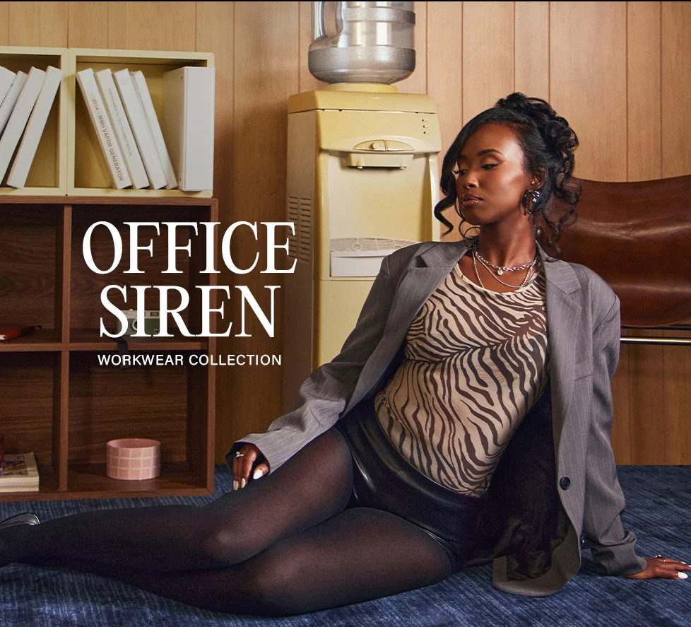Woman models grey pinstripe blazer, zebra top, black shorts, and tights for the chic Office Siren Workwear Collection.