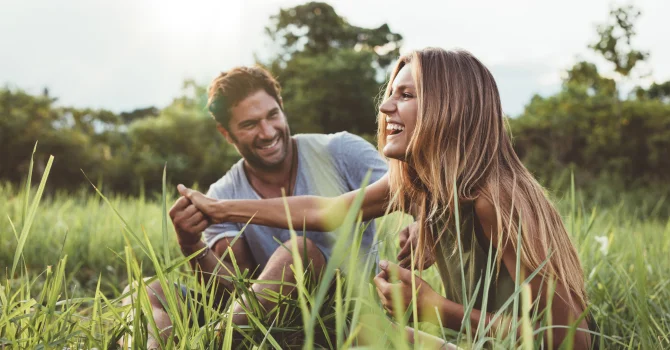 A 30 Something couple sitting in a field together