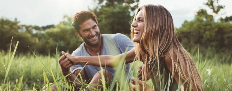 A 30 Something couple sitting in a field together