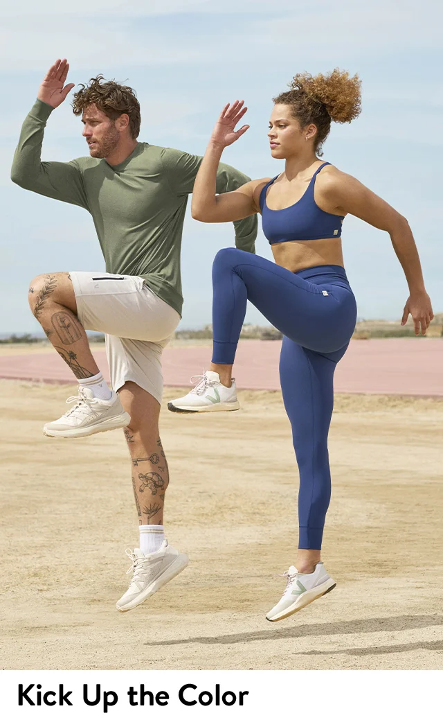 A man and woman exercising. The man wears a green top and white shorts. The woman wears a blue sports bra and matching leggings.