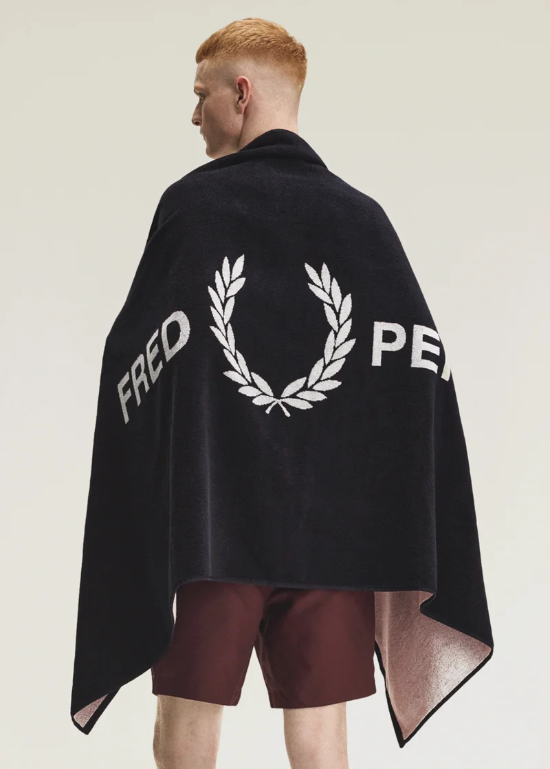 White model wearing a Fred Perry Navy Beach Towel