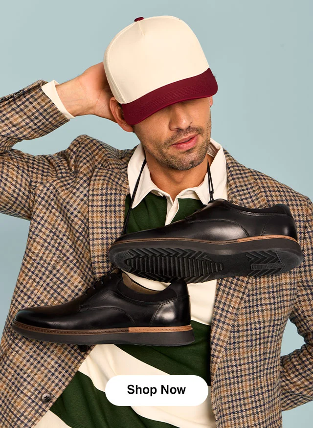 A man in a baseball cap, rugby shirt and plaid blazer holding the Hank derby in Black. Shop Men’s.