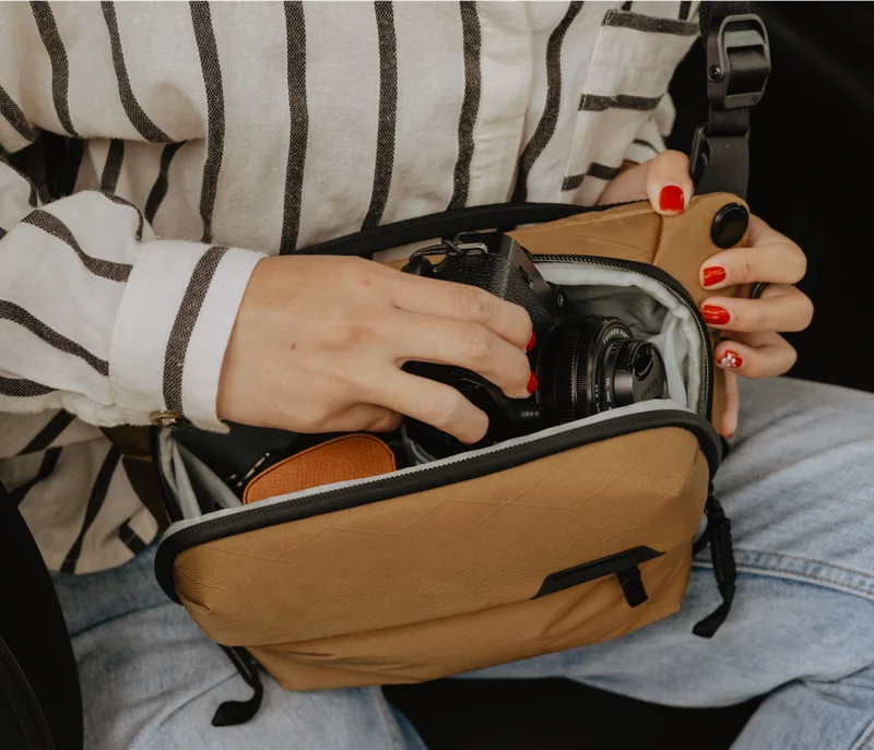 Woman loading camera into coyote everyday sling