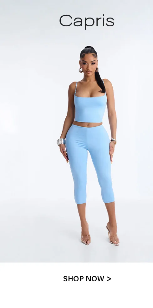 Stylish woman poses in a vibrant baby blue two-piece crop top and capri leggings set, accessorized, promoting the Capris collection. Shop now.