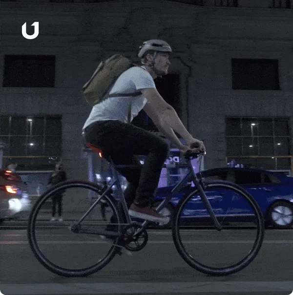 GIF of commuters riding around the city during day and night.