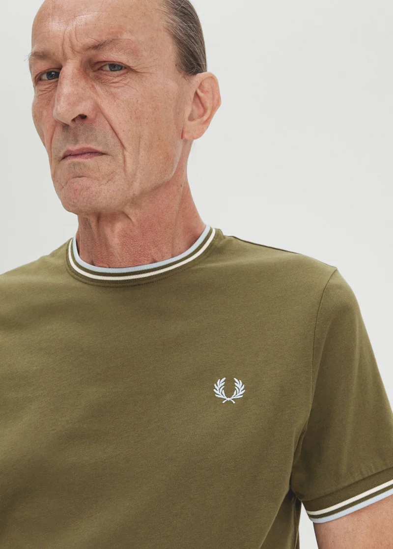 Male model wearing light green fred perry polo shirt