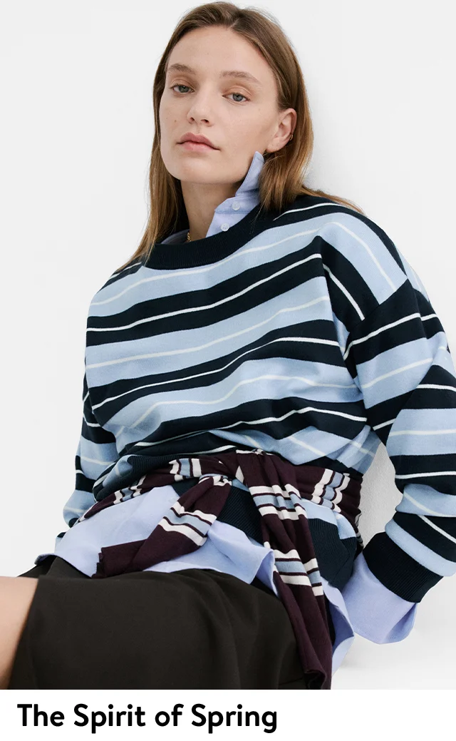 A woman wearing a striped top with another tied around her waist.