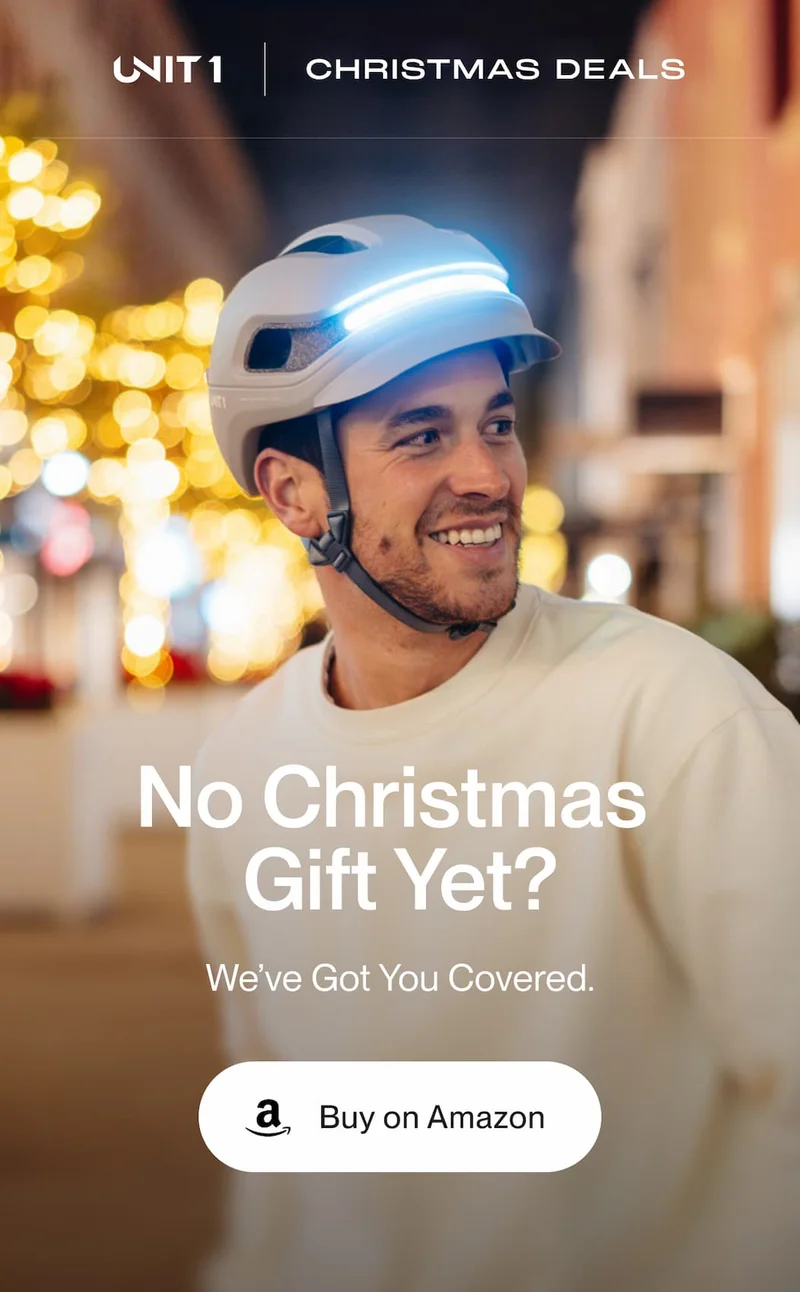 UNIT 1 smart helmet with integrated front light worn by a rider at night, Christmas lights in the background, with the message “No Christmas Gift Yet? We’ve Got You Covered” and a “Buy on Amazon” button.