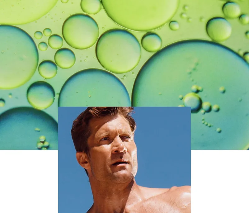 Abstract green liquid bubbles above a person outdoors under a blue sky.