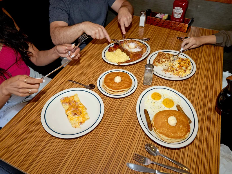 A group of friends enjoying four House Faves items, including the Breakfast Faves Combo
