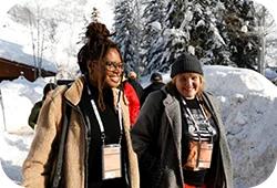 Two Festival attendees smiling and walking in the snow.