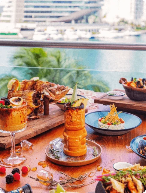 Image Description: An array of dishes and cocktails at Gran Puerto Marina, a restaurant in Cancun