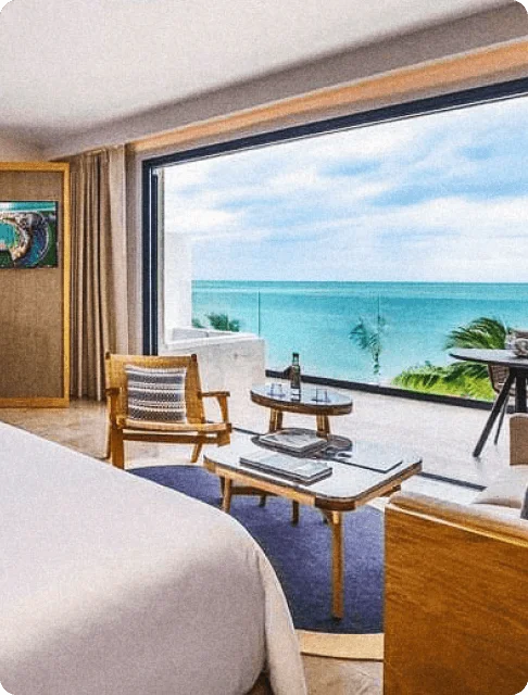 Image Description: Interior of a hotel room with a balcony overlooking the ocean at Haven Riviera Cancun