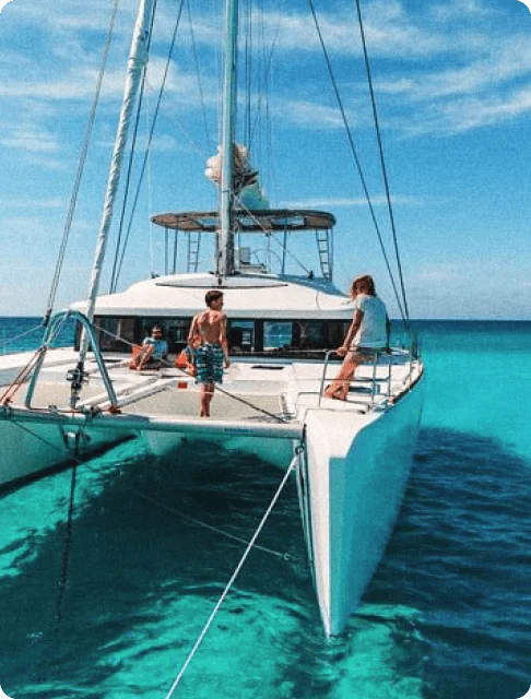 Image Description: Travelers on a docked catamaran amid crystal clear waters