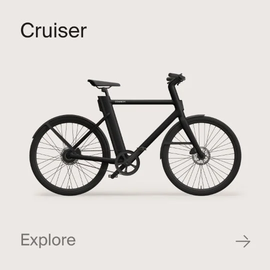 A graphic composition showing a Cowboy Cruiser bike. Text in the image reads "Cruiser" and "explore".