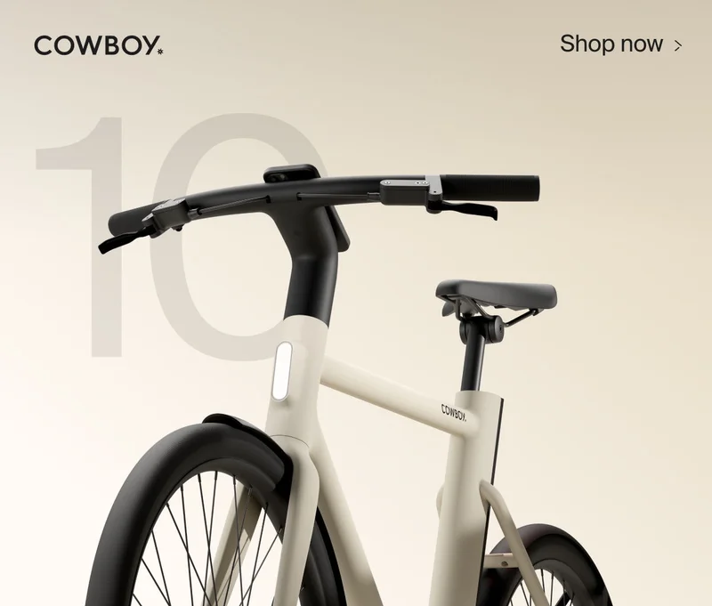 A graphic composition. A render of a Cowbiy Cruiser bike, seen from a low front-on angle, is positioned over the number 10. The Cowboy logo is in the top left and a Shop Now CTA in the top right corner.