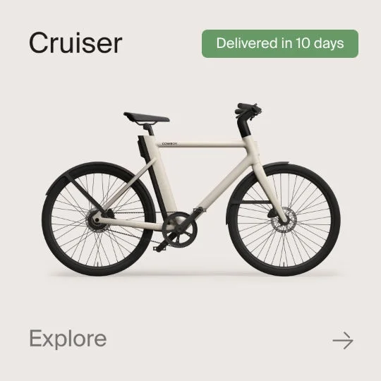 A graphic composition showing a Cowboy Cruiser bike. Text in the image reads "Cruiser", "Shipped in 10 Days" and "explore".